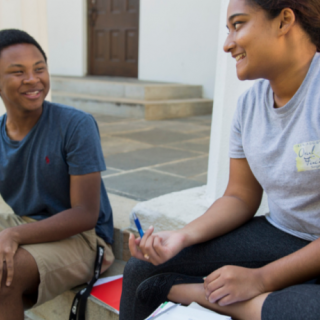 Students talking on the steps of a building at UGA